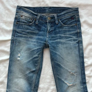Lågmidjade jeans med slitningar - Snygga blå jeans med slitningar 😎 taggen säger W26, innerbenslängd 75cm, midjemått ca 72cm💝💝Har inga bilder på för de tyvärr är för små för mig 
