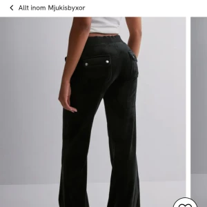 Svarta mjukisbyxor med knappar - Snygga svarta mjukisbyxor med knappar på bakfickorna och snörning i midjan. Perfekta för en avslappnad stil med en skön passform.