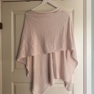 poncho - Säljer en poncho med ett subtilt mönster. Den har en lös passform och är perfekt för lager-på-lager-stil. Passar bra till både vardag och speciella tillfällen.