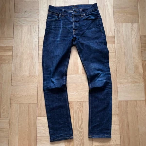 Blåa Nudie Jeans - Ett par mörkblåa Nudie Jeans. W31 L32. Mycket bra skick. Modell: Grim Tim. Hör av er ifall ni har några frågor!