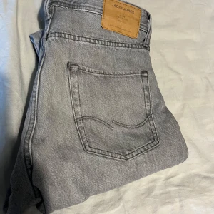 Grå jeans från Jack & Jones - Snygga grå jeans från Jack & Jones i modellen Loose Chris. De har en loose passform och är tillverkade i jeansmaterial. Perfekta för en avslappnad stil. Knappast använda så dom är i bra skick.