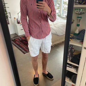 Rutig skjorta från Ralph Lauren - Snygg rutig skjorta från Ralph Lauren i rött och blått. Skjortan har långa ärmar och knappar framtill. Perfekt för en stilren look.😊