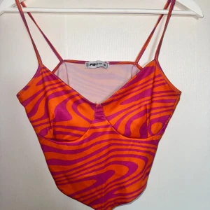 Orange och rosa linne  - Snyggt linne från newyorker i en cool orange och rosa färgkombination med vågigt mönster. Den har smala axelband och en stilren design som verkligen sticker ut. 