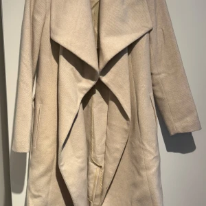 Beige kappa från Mango  - Klassisk kappa från Mango, varsamt använd. Storlek M. 