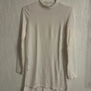 Vit halvpolo i lång modell med slits - Stor garderobrensning♻️Se gärna mina andra annonser. Pris går att diskutera vid flerköp🌸