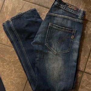 Blå jeans med slitningar - Snygga blå jeans med en klassisk femficksdesign och coola slitningar för en avslappnad look. De har en rak passform och är perfekta för en casual stil. Jeansen har en dragkedja och knapp framtill. Riktigt bra skick och extremt snygg passform.