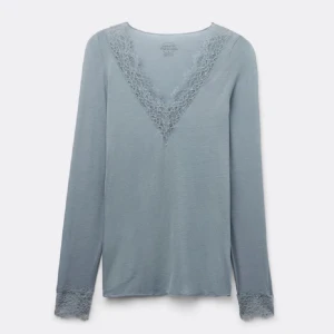 Intimissimi tröja! - Säljer en ljusblå långärmad topp med v-ringad spetsdetalj vid halsen och spets vid ärmsluten. Perfekt för en stilren och elegant look. Passar bra till både jeans och kjol.