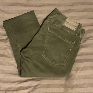 Replay Anbass Jeans - Snygga och sköna jeans från Replay i modellen Anbass. De har en klassisk femficksdesign och en diskret logga på bakfickan. Perfekta för en stilren look.