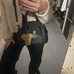 Vivianne Westwood väska  - Super söt vivanne Westwood väska, köpt på vinted med prislapp kvar. Själv andvänt den ca en månad så den är så gott som ny och inga defekter alls. Går att ha som cross shoulder och runt armen i handtagen. Man får plats med super mycket trots att den inte är allt för stor. Perfekt till vardags och fest! I veganskt läder