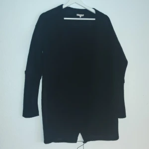 Svart långärmad kofta från Filippa K - Snygg och stilren svart kofta från Filippa K Soft Sport. Perfekt för en avslappnad och elegant look. Koftan har långa ärmar och en enkel design som gör den lätt att matcha med olika outfits.