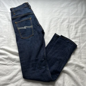 Mörkblå jeans från Nudie Jeans - Snygga mörkblå jeans från Nudie. Perfekta för en stilren look. De har en slim fit passform och är tillverkade i slitstarkt denim. Säljer för att de inte passar mig. Pris kan diskuteras.Nypris: 1600