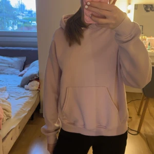 Ljusrosa hoodie - Mysig ljusrosa hoodie med känguruficka framtill. Perfekt för en avslappnad stil och bekväma dagar. Passar bra till jeans eller leggings.