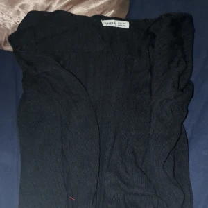 Svart  kofta från Shein - Säljer en svart stickad tröja från Shein. Tröjan har en ribbad design och är perfekt för kyligare dagar. Den är tillverkad i Kina och passar bra för en stilren look. Perfekt för att hålla sig varm och snygg!