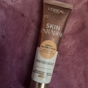 L'Oréal Paris Skin Paradise Tinted Water-Cream - L'Oréal Paris Skin Paradise Tinted Water-Cream i nyansen Light 02. Denna tonade fuktighetskräm ger en perfekt och hälsosam lyster med SPF 20. Perfekt för en naturlig look med extra skydd.