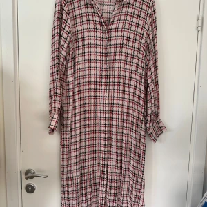 Skjortklänning från Gestuz - Superskön mönstrad klänning från Gestuz, storlek 40-42. Dolda knappar fram och fina klädda knappar i ärmslut och vid halsringningen. Nästan nyskick, nypris 1799:-.   Snygg både som den är eller med skärp i midjan. Eller öppen över jeans. Eller hursom.   Hämtas i Stockholm eller skickas mot porto.