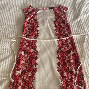 Blommig klänning med knytband  - Klänning med röda blommor från Kappahl kommer med knytband okej skick 