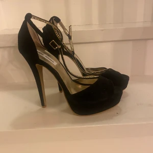 Svarta pumps - Oanvända Svarta pumps med guldkedjor från Steve Madden! 