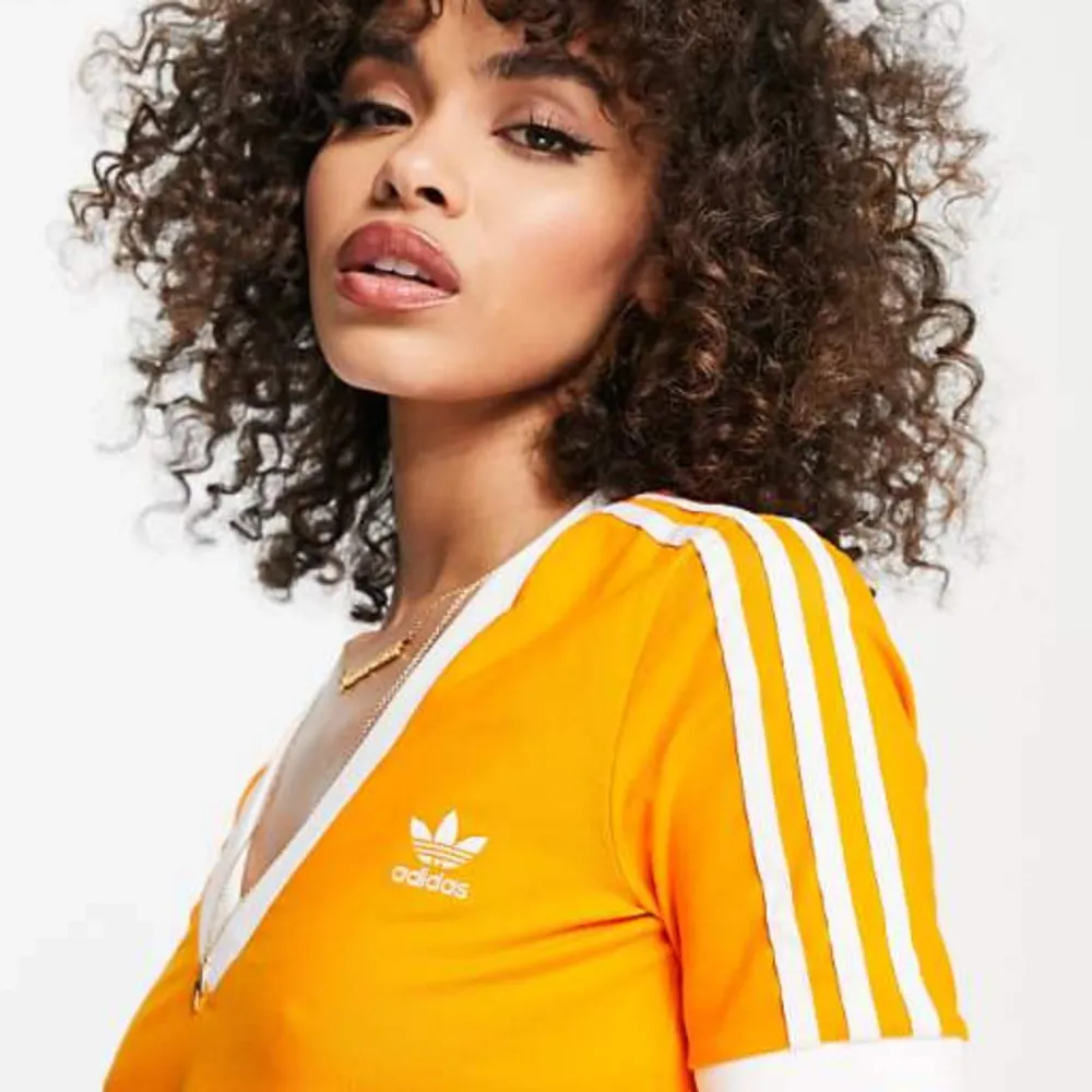 Adidas crop top. Storlek 38, orange / solros. Nyskick, aldrig använd. Frakt tillkommer. Tar ej retur . Toppar.