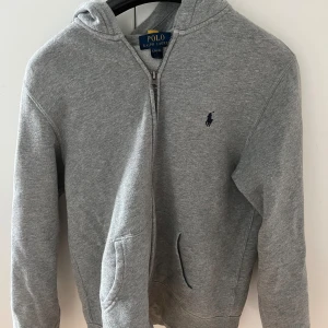 Ralph lauren Hoodie (zip) - Säljer denna snygga Ralph lauren zip i ett bra skick, använd men fortfarande bra omhändertagen. Storlek 14-16 = XS/S. Jag e 166 ungefär och den passar mig på gränsen. Hör av er vid funderingar mvh Linus nypris 1095, så 400 är bra pris💸
