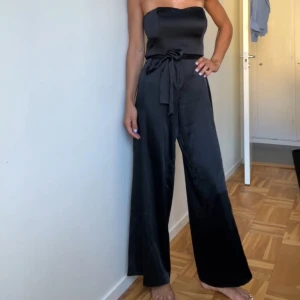 Svart satinjumpsuit - Svart satinjumpsuit från H&M i strl 36! I fint skick