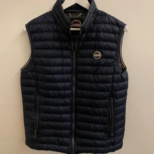 Marinblå Colmar Väst - En riktigt skön Colmar väst i storleken 48, Skicket på den är väldigt bra utan några defekter. Jag säljer den då jag inte använder den längre. Hör av dig vid fler frågor eller bilder 