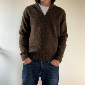 Brun stickad tröja med dragkedja - Säljer en mysig skogs grön stickad tröja med dragkedja. Perfekt för höst och vinter! Den har långa ärmar och en ribbad kant vid ärmslut och nederkant. Tröjan är i nyskick och passar perfekt för kyliga dagar.