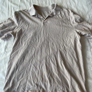 Beige pikétröja från H&M - Säljer en beige pikétröja från H&M i storlek M. Tröjan är i bomull och har korta ärmar. Den är skrynklig så i behov av strykning. Annars perfekt för vardagsbruk. Passformen är normal och den har en klassisk krage. Frågor? Skriv!