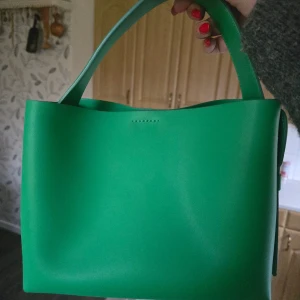 Arket väska - Arket väska i den populära gröna färgen som sålde slut direkt. Mått 23 cm x 19 cm x 10,5 cm. Fläck på ena sidan från en annan läderväska - se bild.