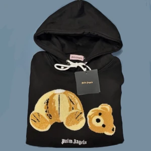Palm Angels Hoodie Teddy Bear *HELT NY+TAGS* - Helt ny Palm Angels teddy bear hoodie. Ikonisk design med teddybjörnsdetalj på framsidan. Skön och passar både till vardags och när du vill ha en stilren look. Finns i storlek M men passar som S