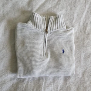 Vit stickad tröja från Polo Ralph Lauren - Säljer en superfin vit half zip tröja från Polo Ralph Lauren. Super snygg och stilren i bra skick som är jätte skön för hösten. Har en liten slitage som syns knappt men är inringand vid sista bilden. Skriv för fler frågor