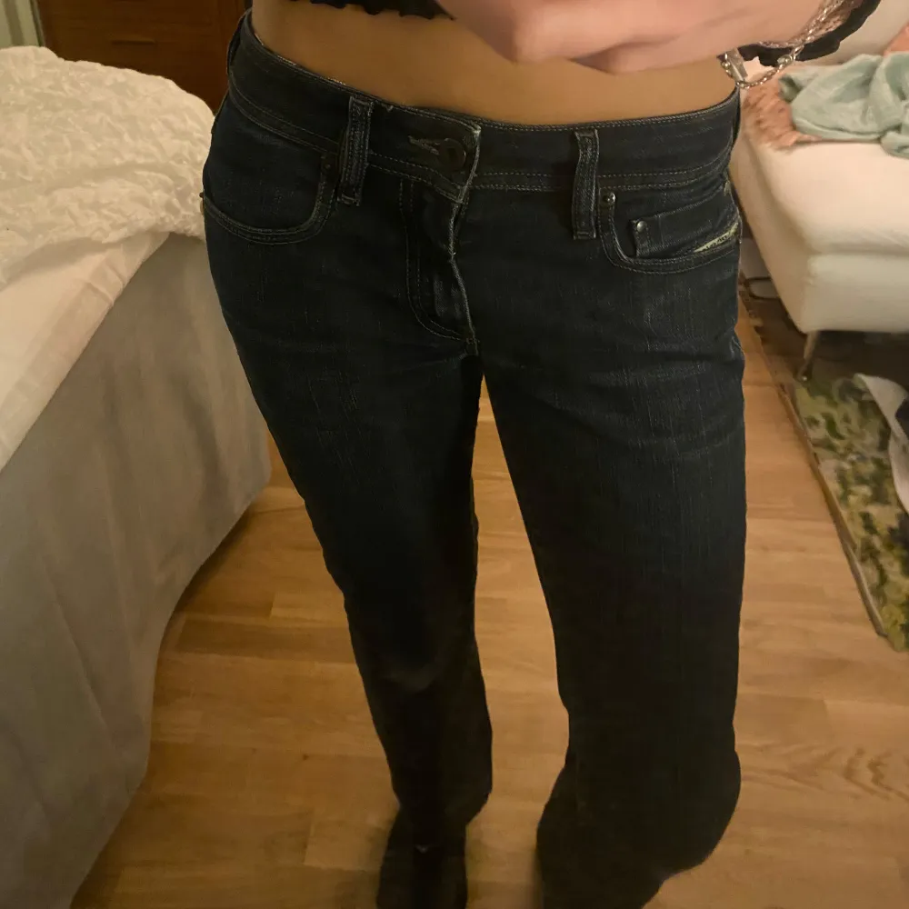 Säljer snygga mörkblåa dieseljeans som är midwaist och straight. Sömmen längst ner på benen är uppsprättad, se bild5. Väldigt bra skick, slitningarna på knäna är en del av designen! Midjemått 37cm innerben 75cm. Köpta secondhand för 350💗. Jeans & Byxor.