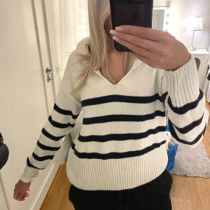 Stickad tröja - Superfin stickad tröja med v-ringning plus krage, med marinblå streck. Superfin till ett par byxor året runt eller kjol på sommaren🤍hör av dig vid frågor