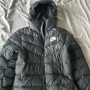 Nike jacka - Säljer den här snygga Nike jackan då jag inte använt mycket den är i (9/10) skick då den har nån lätt fläck (går tvätta bort) den är lätt, skön och bra varm till vintern  Nypris 1400 Jag säljer för 600