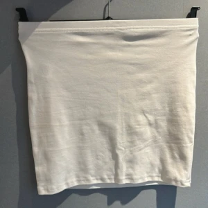 Vit kjol - Säljer en enkel och stilren vit kjol. Perfekt för sommardagar eller att matcha med en färgglad topp. Kjolen är i ett mjukt och bekvämt material.