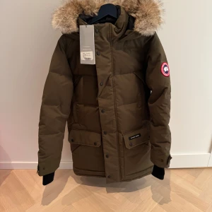Canada Goose Emory Parka - Helt ny och oanvänd Canada Goose Emory Parka, med tillhörande etiketter kvar. Äkta pälskrage. Nypris 19 275 kr på Canada Goose hemsida.  Säljs på grund av felköpt storlek.