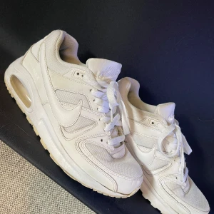 Vita Nike sneakers - Säljer ett par vita Nike sneakers i storlek dam 40. De är i bra skick med lite slitage på sulorna. Perfekta för vardagsbruk med en stilren design och bekväm passform. Skorna har snörning och en klassisk Nike-logga på sidan.