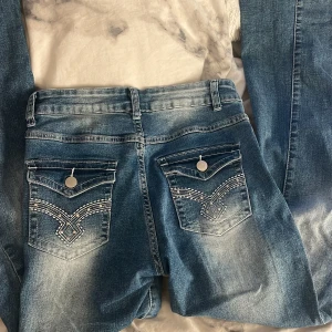 Blåa jeans med coola fickor - Säljer dessa blåa bootcut jeans som är typ högmidjade eller mid Rise. Dom har snygga fickor och är i storlek XS/34. Använda fåtal gånger. Pris går att diskutera 💞