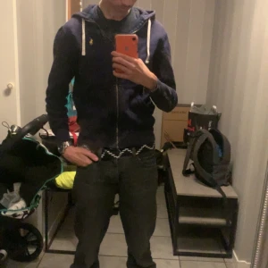 Mörkblå Ralph louren zip - Säljer en mörkblå huvtröja från Polo Ralph Lauren med dragkedja och broderad logga på bröstet. Tröjan är i fint skick och är i storlek xs. Tveka inte att höras av vid intresse😊