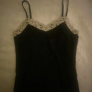 Svart linne med spetsdetaljer från Inteimissimi - Säljer mitt oanvända linne från intemissimi i storlek S!💕⚡️🫶🏻pris kan diskuteras.✌️💖⭐️