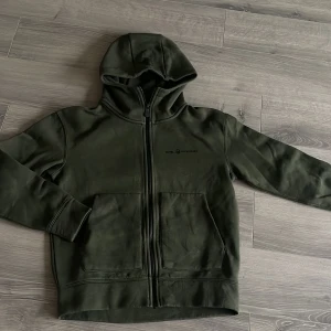 Grön hoodie från Sail Racing - Säljer en grön hoodie från Sail Racing med dragkedja. Denna modell är lite tjockare vilket gör den väldigt skön! 1500kr på sail racings hemisida