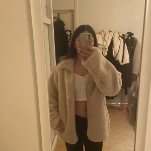 Beige teddyjacka Storlek S - Mysig beige teddyjacka med dragkedja framtill. Perfekt för kyliga dagar med sin oversized passform och långa ärmar. Jackan är i storlek S och använd endast 2 gånger.