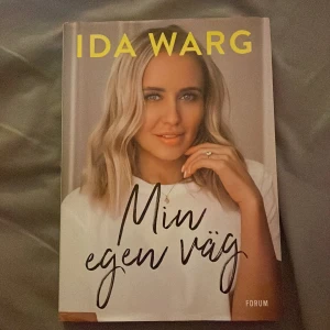 Min egen väg (signerad) - Boken 'Min egen väg' av Ida Warg handlar om hennes resa från en liten stad till att bli en influencer. Hon delar med sig av personliga upplevelser och utmaningar, inklusive motstridiga känslor och tankar kring föräldraskap. En inspirerande berättelse om att våga följa sin egen väg, oavsett hinder.