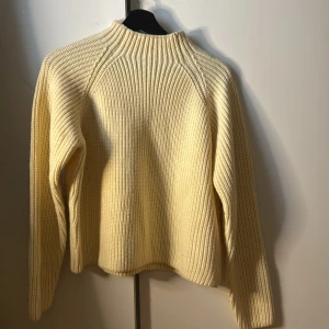 Beige stickad tröja från Zara - Säljer en  beige stickad tröja från Zara. Tröjan har en ribbad design och långa ärmar, perfekt för kyligare dagar. Den har en klassisk passform som är rätt så bekväm.