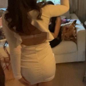 Ljusrosa klänning med öppen rygg - Snygg ljusrosa klänning med lång ärm och en öppen rygg med volang. Är lite sliten vid knäppet men fungerar ändå fint!