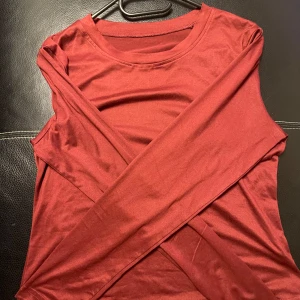 Röd långärmad tröja - Säljer en enkel och stilren röd långärmad tröja. Perfekt för en avslappnad look. Tröjan har en rund halsringning och är tillverkad i ett mjukt material.