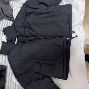 Svart pufferjacka från H&M - Säljer en svart pufferjacka från H&M i storlek XS. Jackan har en dragkedja framtill och är perfekt för kyligare dagar. Den har en stilren design med långa ärmar och praktiska fickor.