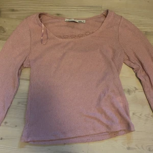 Rosa ribbad topp från 157 - Säljer en söt rosa ribbad topp från lager 157 med spetsdetaljer vid halsringningen. Toppen har långa ärmar och en mjuk, bekväm passform. Perfekt för en avslappnad stil. Pris kan diskuteras💞