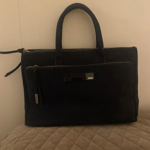 Mörkblå handväska med dragkedja - Elegant mörkblå handväska med flera dragkedjor och praktiska fack. Perfekt för att organisera dina saker. Väskan har två handtag och en stilren design. Den ända defekten syns på sista bilden, men annars är den helt perfekt och oanvänd!💕 