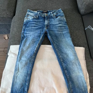 Blå jeans från Jack & Jones - Säljer ett par snygga blå jeans från Jack & Jones med en bra passform. Modellen heter Spray On/Tom. Perfekta för en stilren look. Priset kan diskuteras vid köp av alla tre jeans i min shop, annars 100kr st byxorna är nästan sprillans nya testade en gång 