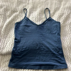 Blå linnetopp från Shein - Säljer en blå linnetopp från Shein med smala axelband och v-ringning. Perfekt för varma dagar eller som ett lager under andra plagg.